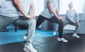 Three people manage joint pain by doing yoga bend at the knee.