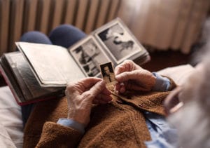A resident sentimentally gazes upon a wallet sized photo of a military man.