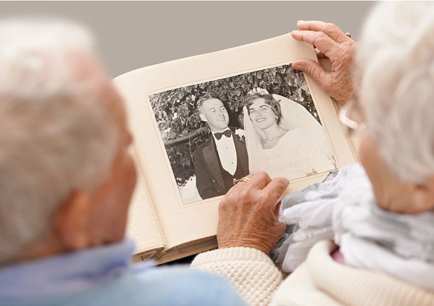 A senior couple looks at their old wedding photos