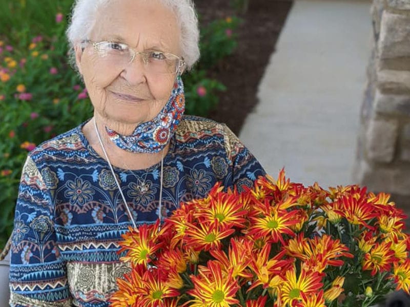 nior citizen woman with flowers in an assisted living facility