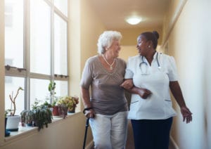 A nurse helps an elderly female assisted living resident